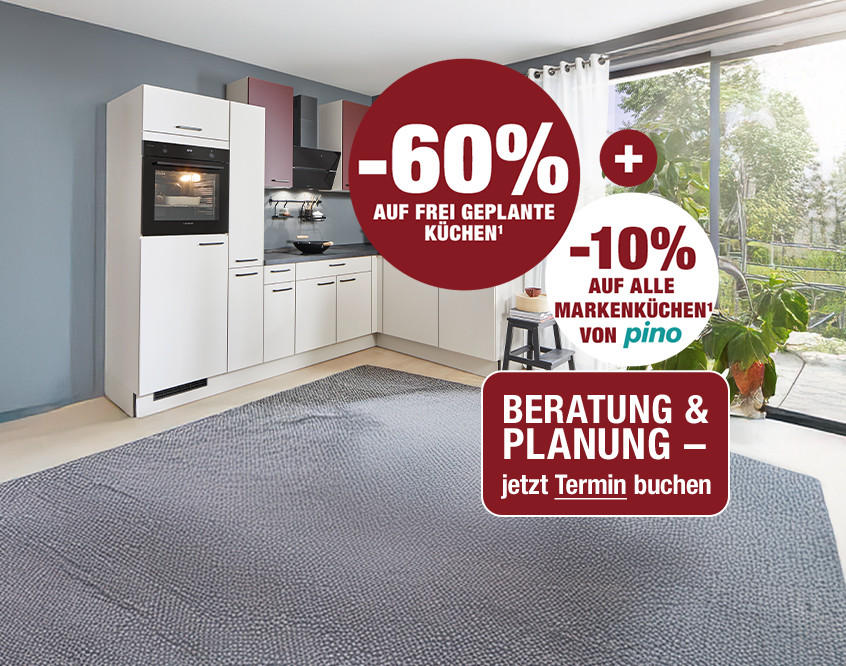 Moderne weiße Küchenzeile mit Backofen, grauer Arbeitsplatte und grauem Teppich vor großen Fenstern mit weißen Vorhängen.