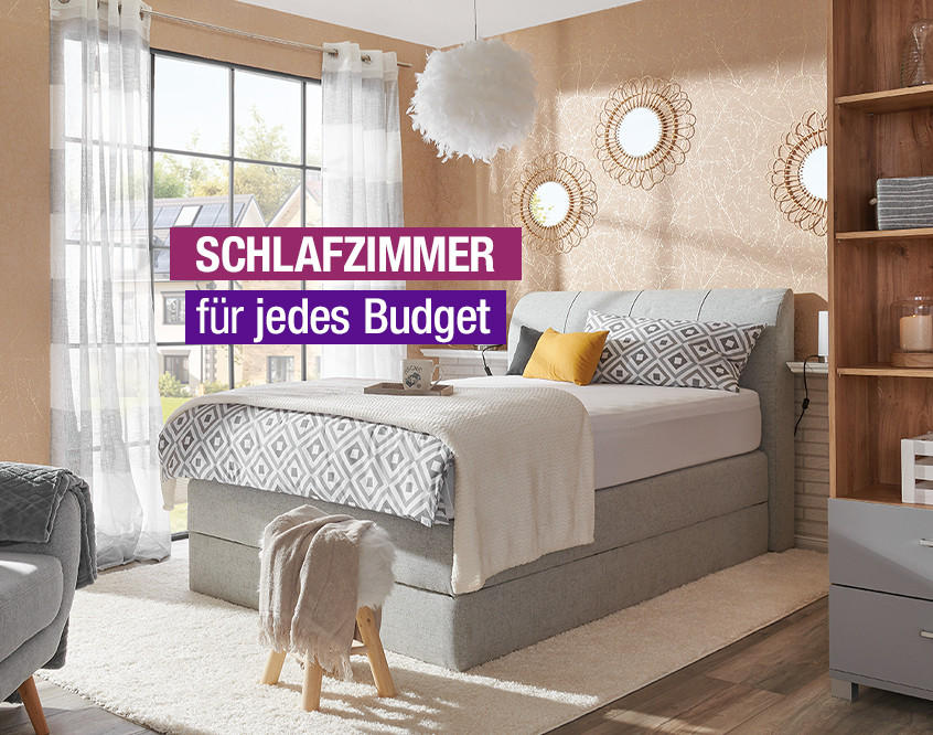 Gemütliches Schlafzimmer mit grauem Bett, gemustertem Bettbezug, gelbem Kissen und Text 'Schlafzimmer für jedes Budget'