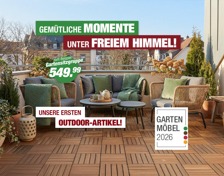 Terrasse mit moderner Gartenmöbelgruppe aus Rattan mit Sitzkissen, Kaffeetisch und Dekoration vor Häuserfassaden