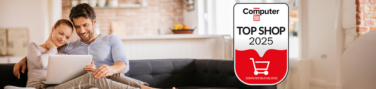 Zertifikat 'Computer Bild Top Shop 2025' neben einem Paar auf dem Sofa mit Tablet in modernem Wohnzimmer