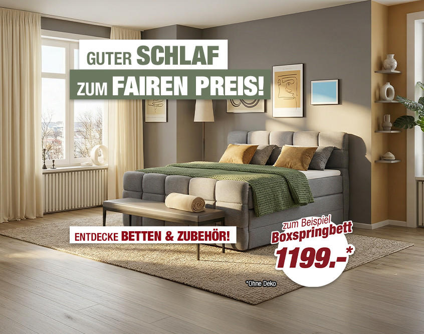 Schlafzimmer mit großem Bett, Sitzbank, Sessel, Teppich und Wandbildern in warmen Farben